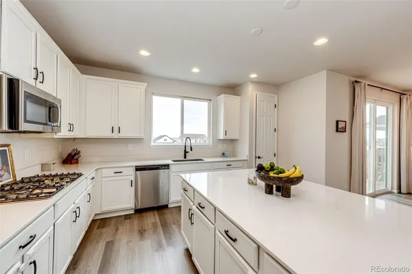 a kitchen with a sink a stove cabinets and counter space