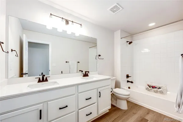 a bathroom with a double vanity sink mirror and toilet