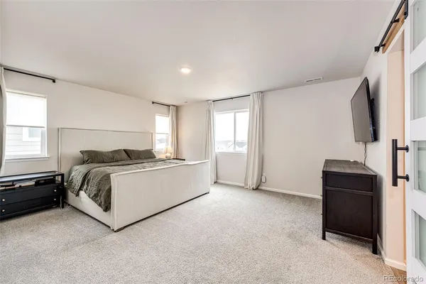 a room with a bed and a flat tv screen on a dresser