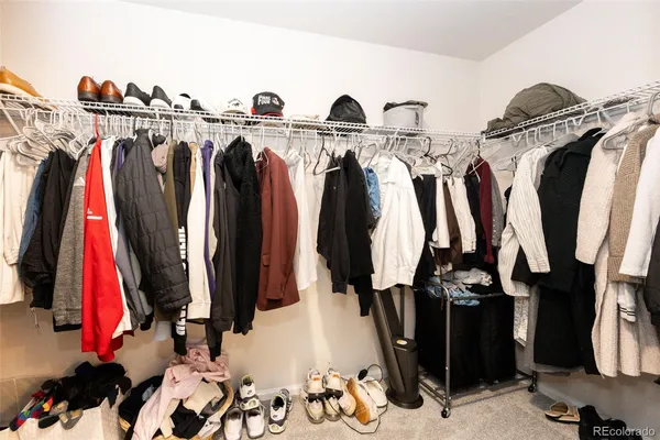 a view of walk in closet with clothes and shoes