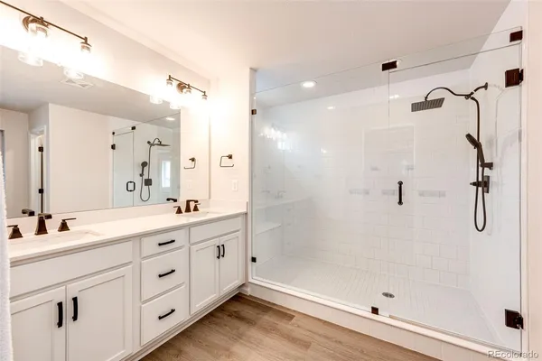 a bathroom with a double vanity sink mirror and shower