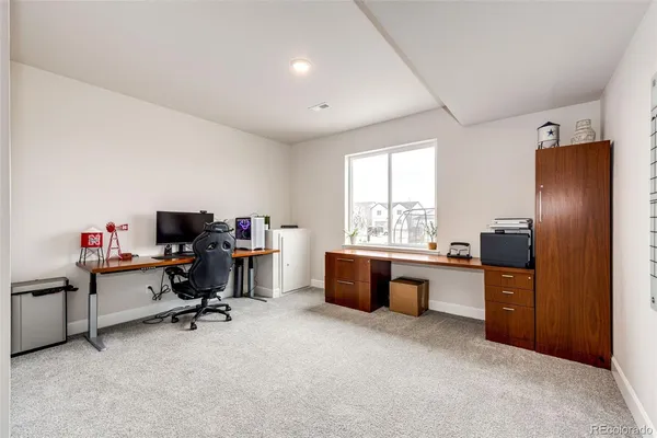 a view of a workspace with furniture and a window