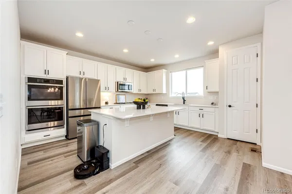 a kitchen with stainless steel appliances a refrigerator sink and microwave
