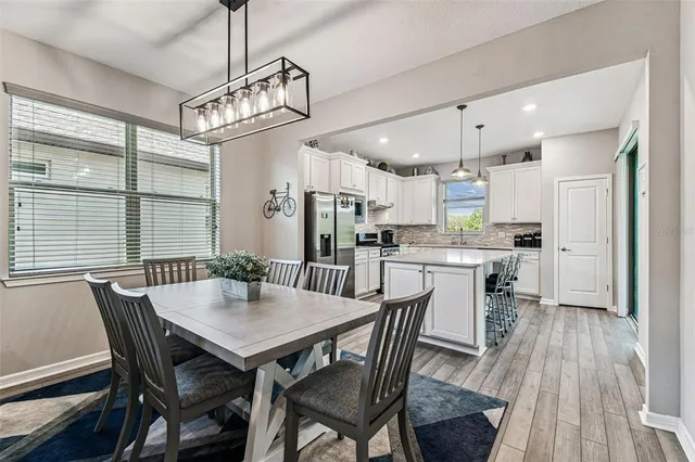 a view of a dining room with furniture a rug and wooden floor