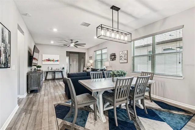 a kitchen with stainless steel appliances a stove a sink a microwave a center island and a table