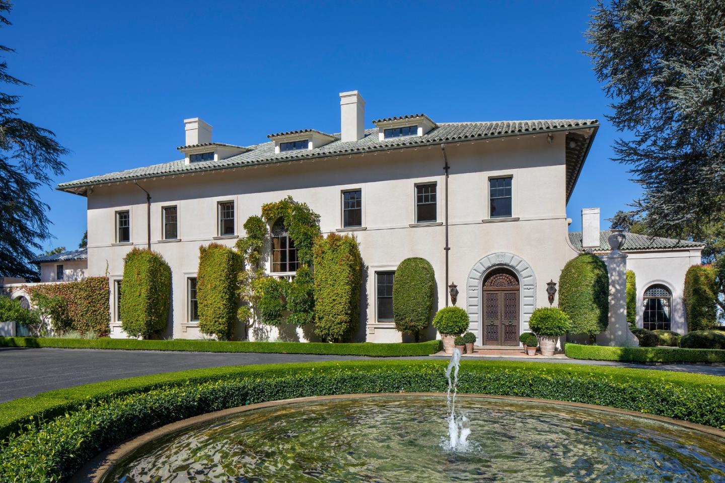 a view of a white house with large windows and a yard