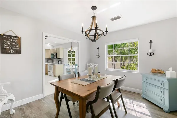 a dining room with wooden floor and a chandelier