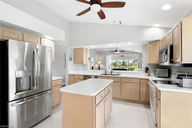 a kitchen with granite countertop a sink stainless steel appliances and cabinets