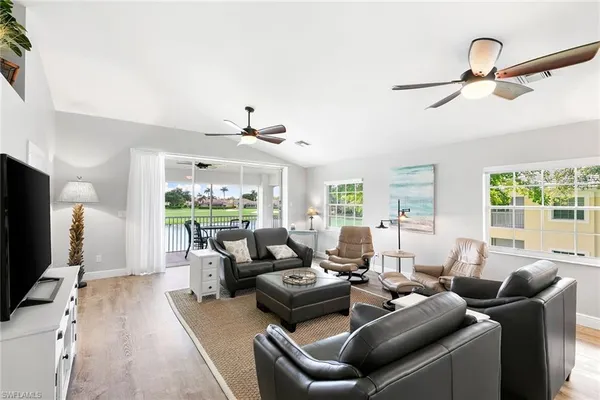a living room with furniture a flat screen tv and a floor to ceiling window