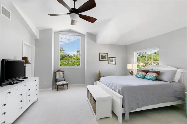 a bedroom with a bed and a flat tv screen on the dresser