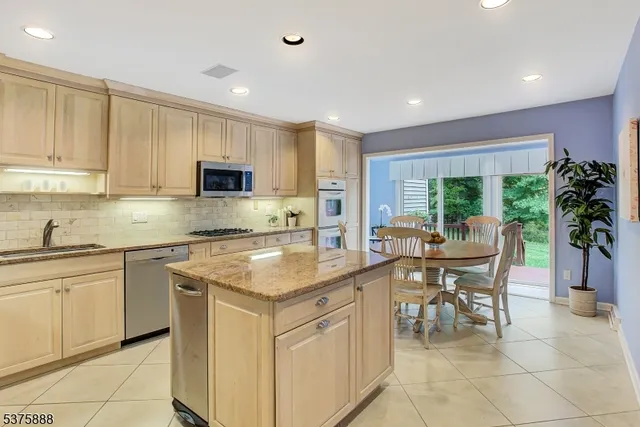 a kitchen with a stove a sink a microwave a dining table and chairs