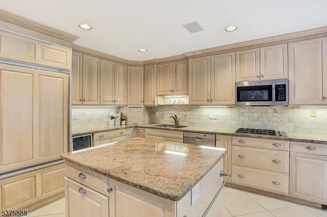 a kitchen with granite countertop white cabinets and stainless steel appliances
