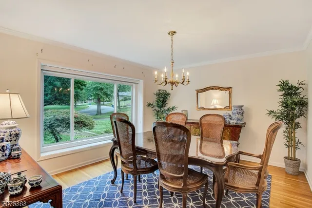 a dining room with furniture a chandelier and wooden floor