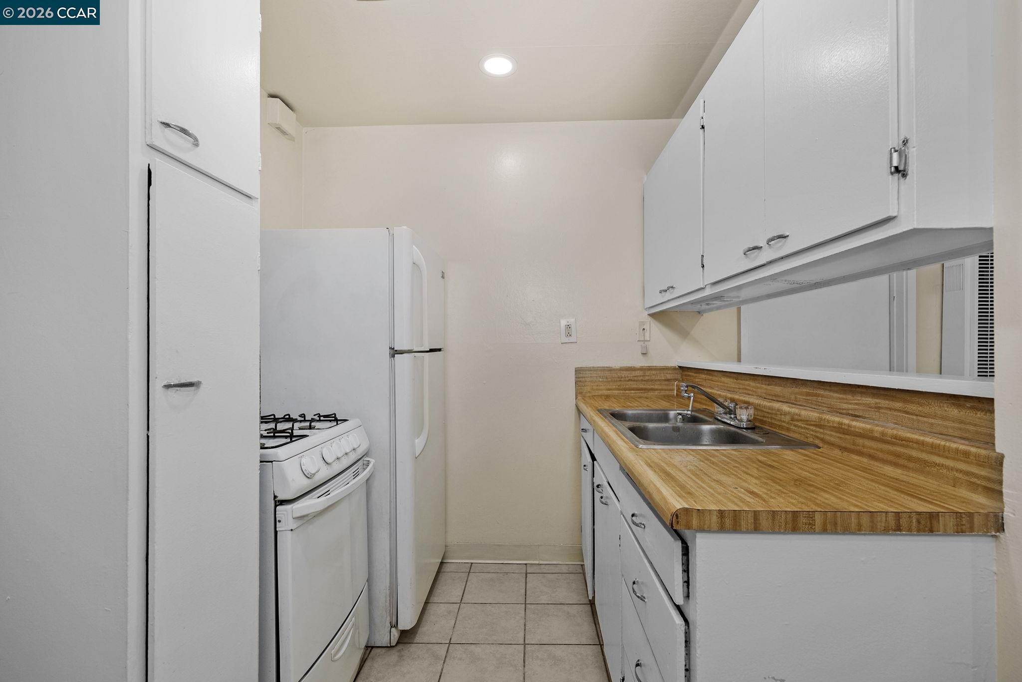 1926 Alcatraz Avenue, Unit 2 Berkeley, CA 94703 - Photo 10 of 13 a kitchen with granite countertop a sink stove and refrigerator