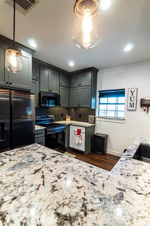 10800 Estate Lane Terrell, TX 75161 - Photo 25 of 30 a kitchen with kitchen island granite countertop a refrigerator stove and sink