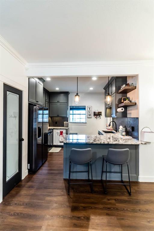 10800 Estate Lane Terrell, TX 75161 - Photo 29 of 30 a room with stainless steel appliances kitchen island granite countertop a table chairs in it and wooden floors