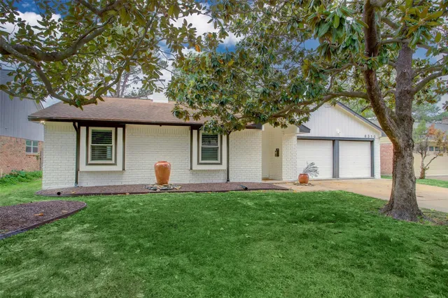 a front view of house with a garden and trees