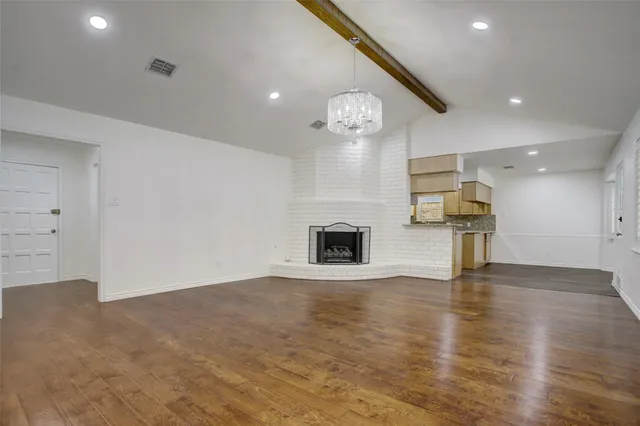 an empty room with wooden floor and fireplace