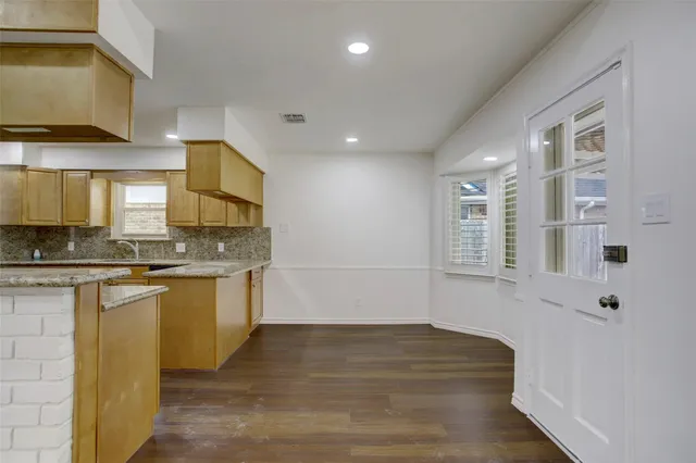 a view of a kitchen with granite countertop a sink and cabinets
