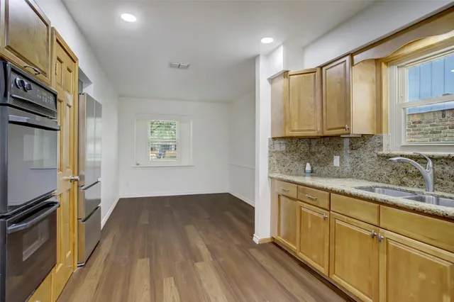a kitchen with wooden floors and white appliances