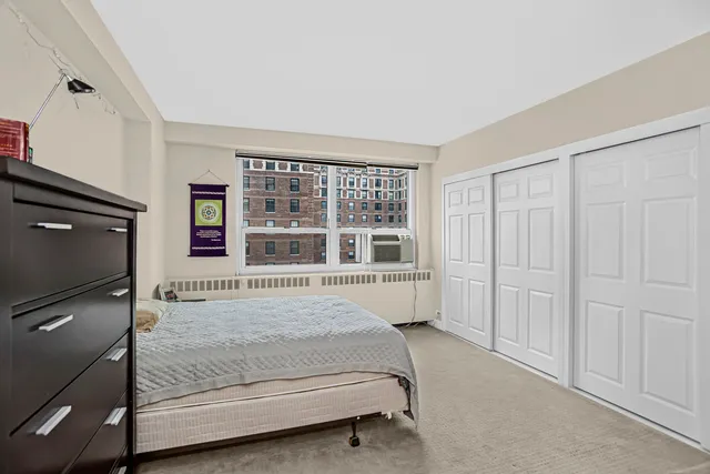 a bed sitting in a spacious bedroom next to a window