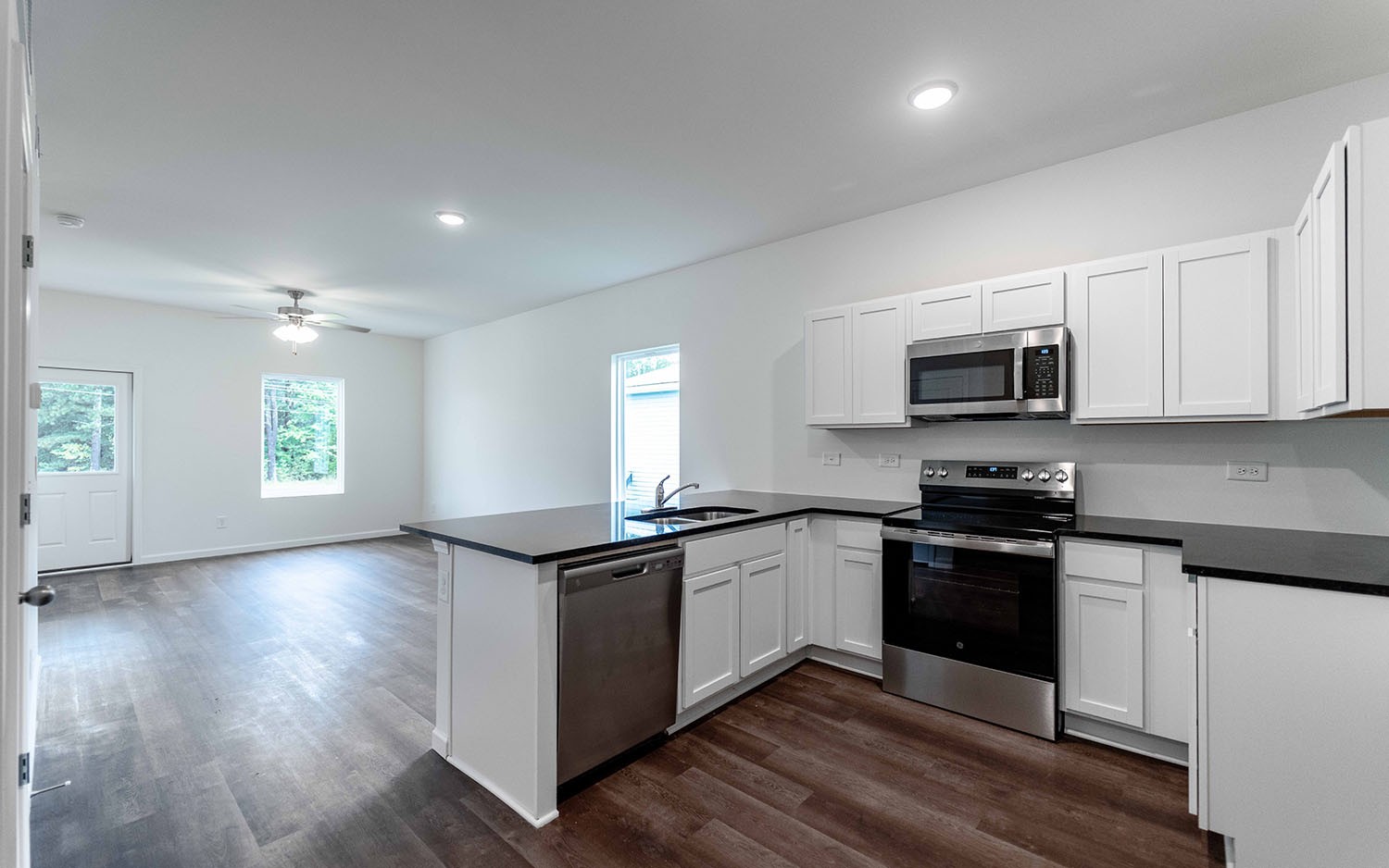 77 Stonehenge Lane Manchester, TN 37355 - Photo 15 of 16 a kitchen with stainless steel appliances granite countertop wooden cabinets a sink a stove a microwave and hard wood floors