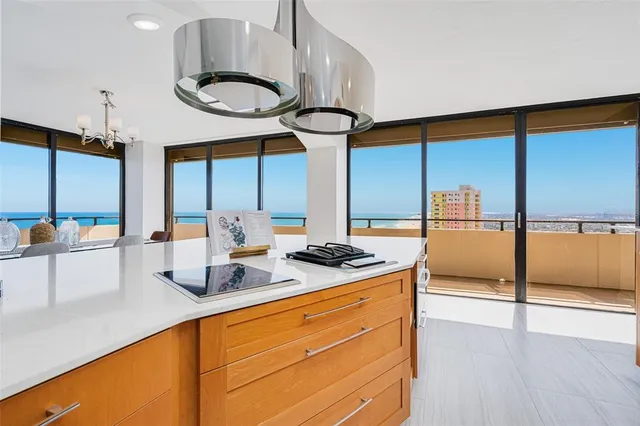 a kitchen with stainless steel appliances granite countertop a sink a stove and a wooden floor