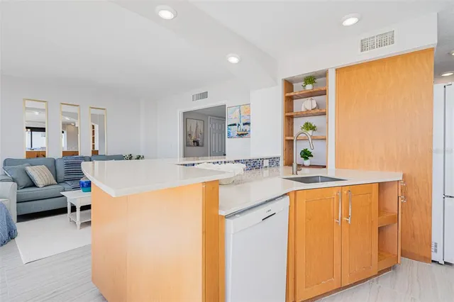 a kitchen with stainless steel appliances granite countertop a sink and a refrigerator