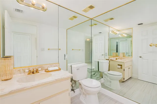 a bathroom with a sink a toilet and a large mirror