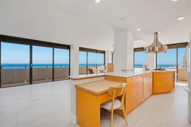 a large white kitchen with a large window and stainless steel appliances