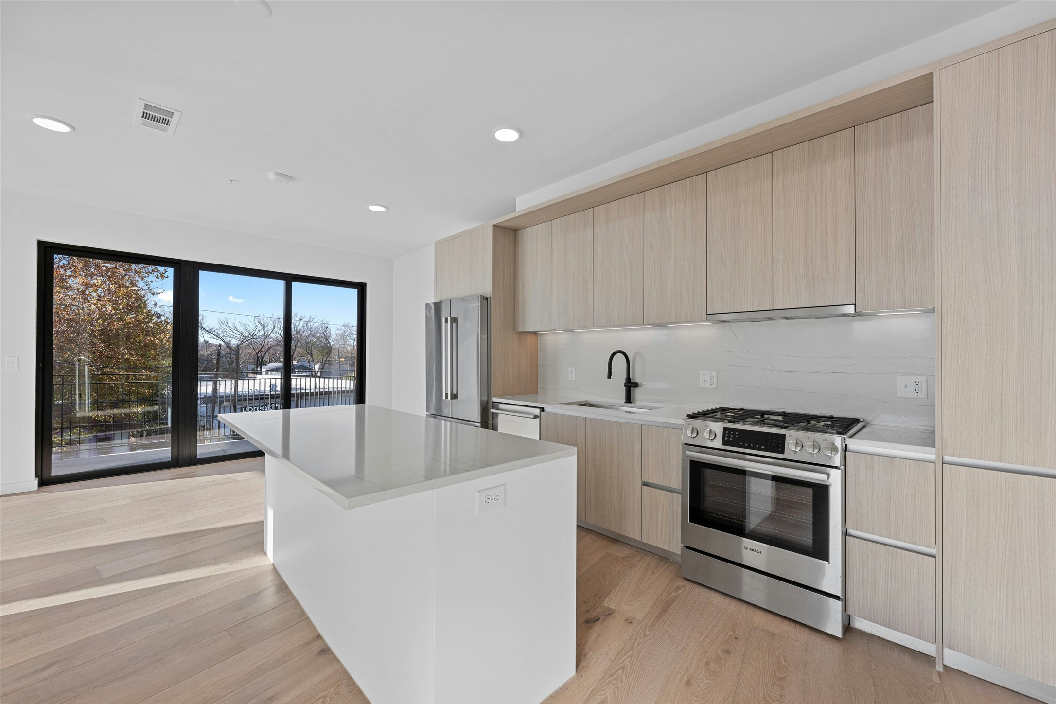 a kitchen with stainless steel appliances granite countertop a stove a sink and a microwave