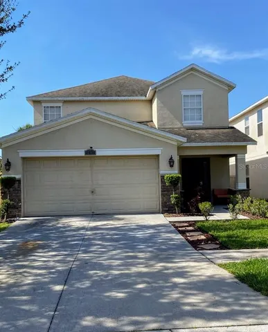 a front view of a house with yard and parking