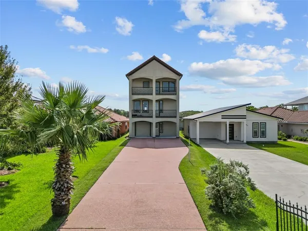 a front view of a house with a yard and potted plants