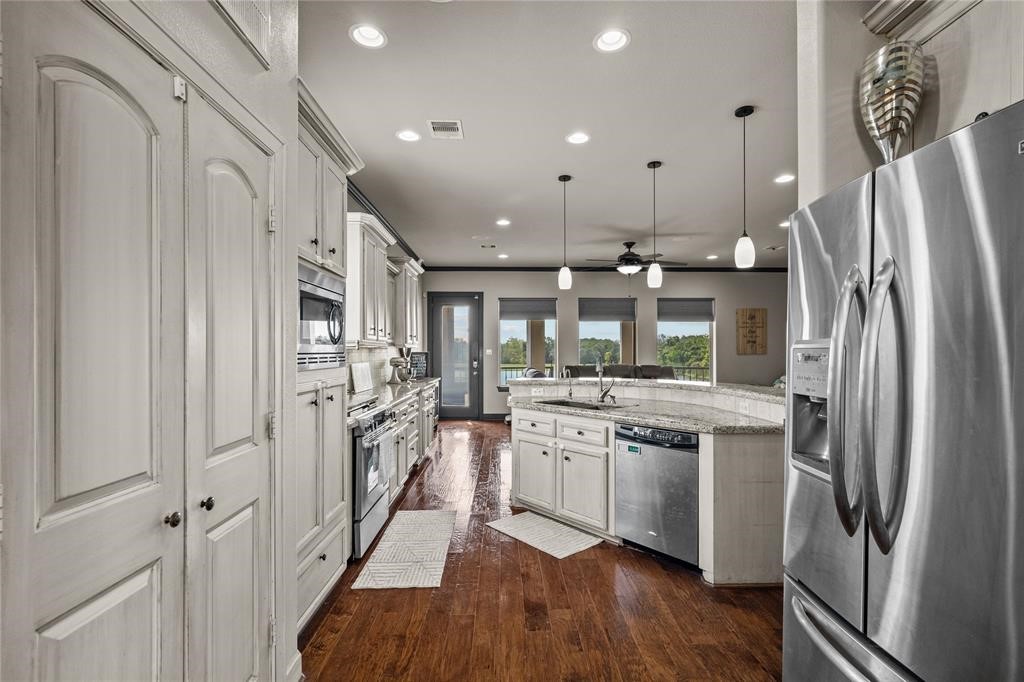 607 28th Street San Leon, TX 77539 - Photo 17 of 44 a kitchen with stainless steel appliances granite countertop a refrigerator a stove and a wooden floors