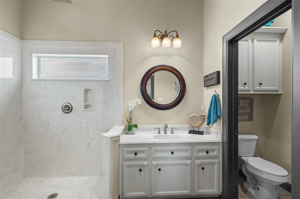 607 28th Street San Leon, TX 77539 - Photo 25 of 44 a bathroom with a double vanity sink a mirror and a toilet