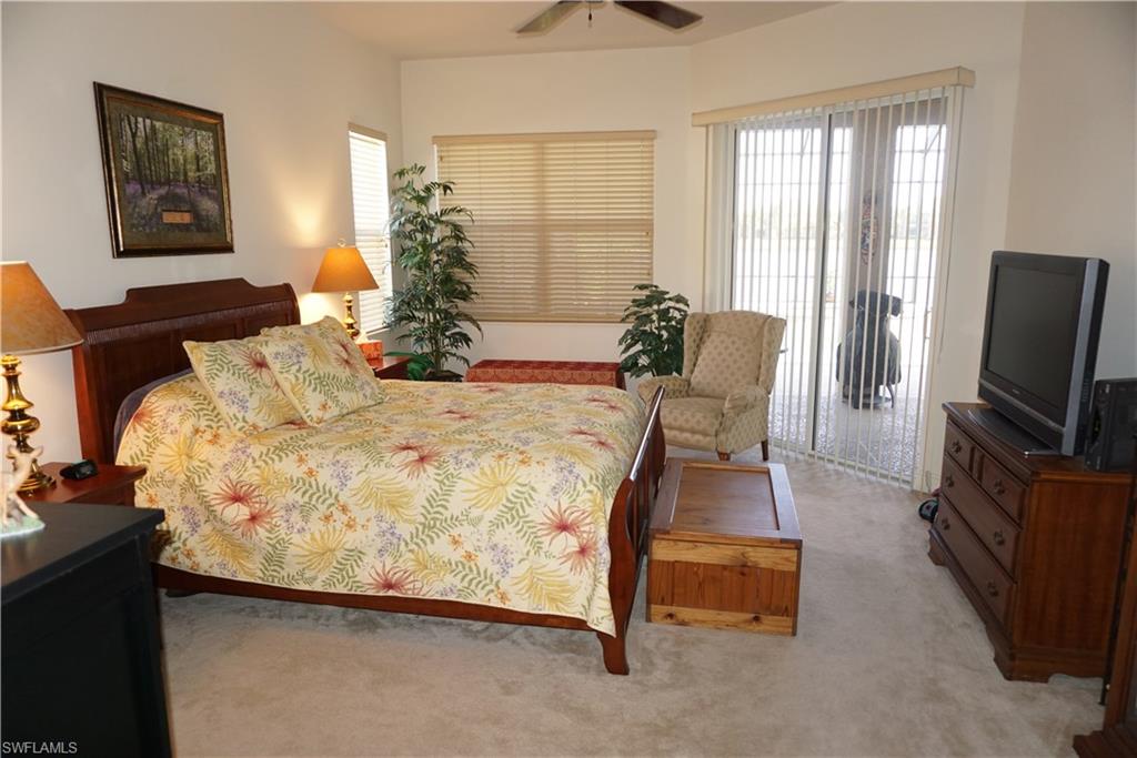 6189 Bunker Place Naples, FL 34113 - Photo 10 of 25 a bed sitting in a bedroom next to a window with tv