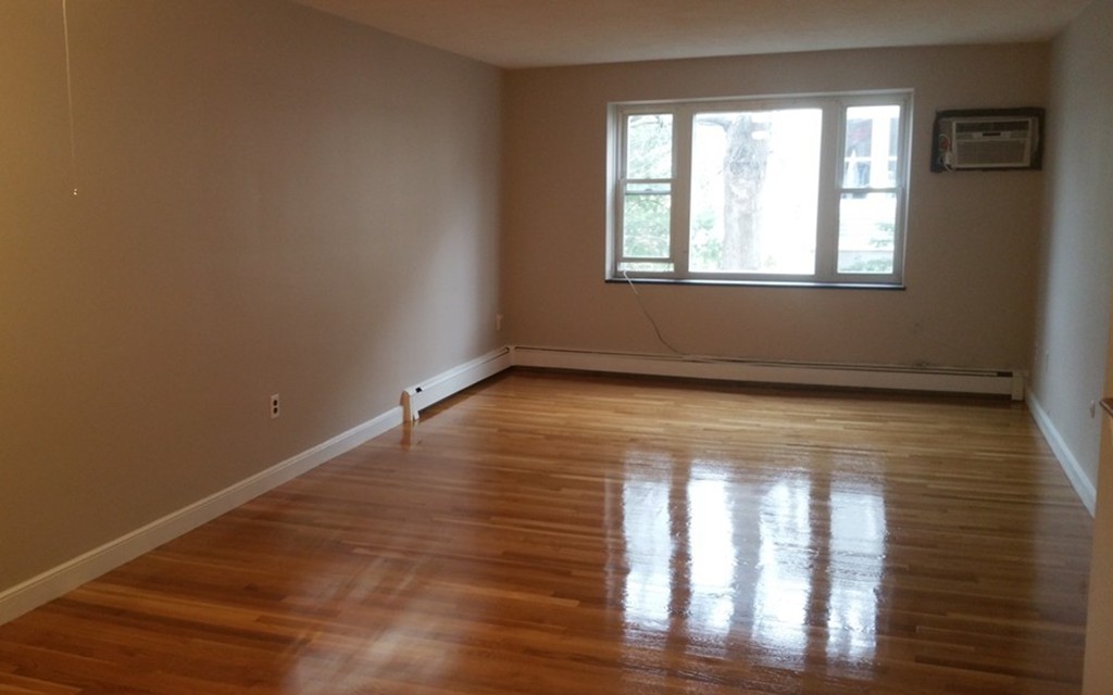100 Summer Street, Unit 14 Watertown, MA 02472 - Photo 2 of 9 a view of an empty room with wooden floor and a window