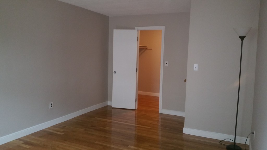 100 Summer Street, Unit 14 Watertown, MA 02472 - Photo 4 of 9 a view of an empty room with wooden floor and closet