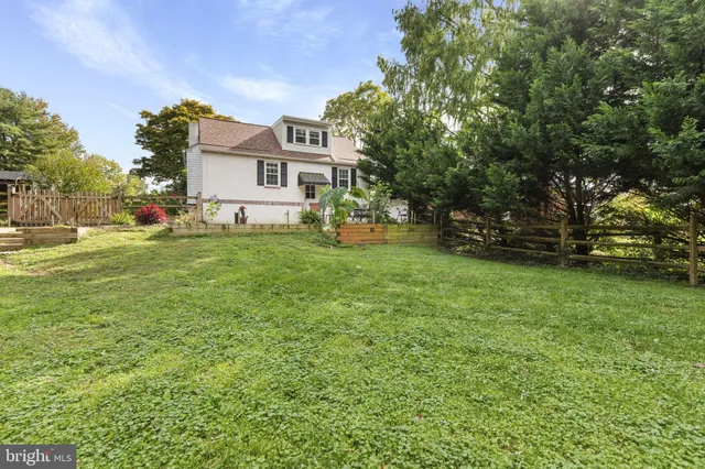 a view of a house with a big yard and large trees