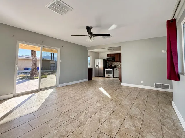 a view of empty room with a window and a ceiling fan