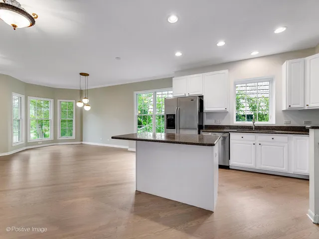 a large kitchen with granite countertop a stove a sink a window and dining table