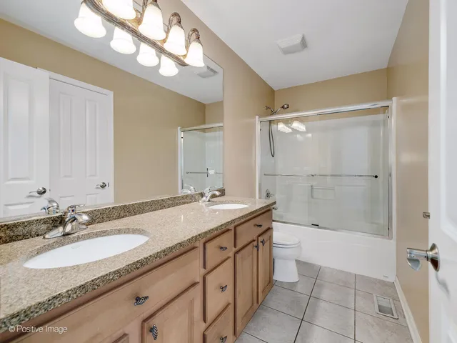 a bathroom with a sink double vanity granite tub and a mirror