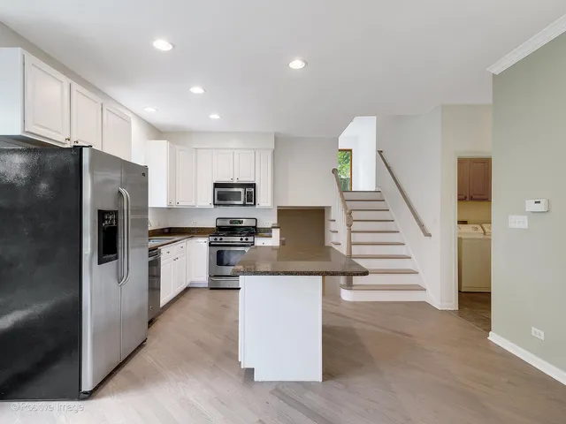 a kitchen with white cabinets and stainless steel appliances