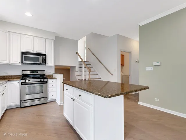 a kitchen with white cabinets appliances and sink