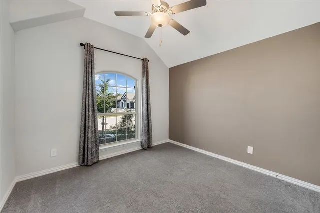 an empty room with chandelier fan