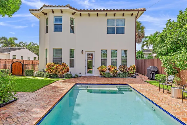 a view of a swimming pool with a garden and trees
