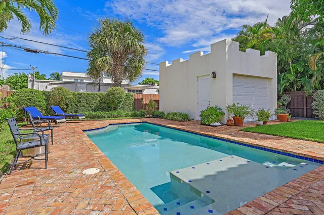 a view of a chair and table in backyard of the house