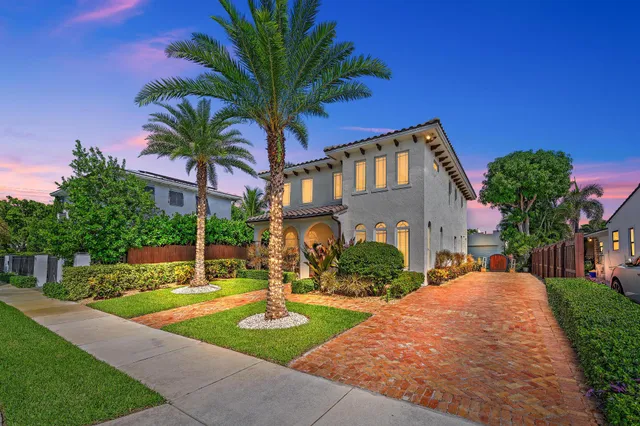 a aerial view of a house with large trees and flower plants