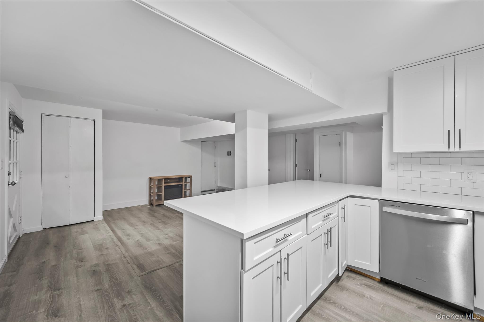 1440 Boston Post Road, Unit 8K Larchmont, NY 10538 - Photo 7 of 20 Kitchen with dishwasher, light countertops, light wood finished floors, and white cabinetry