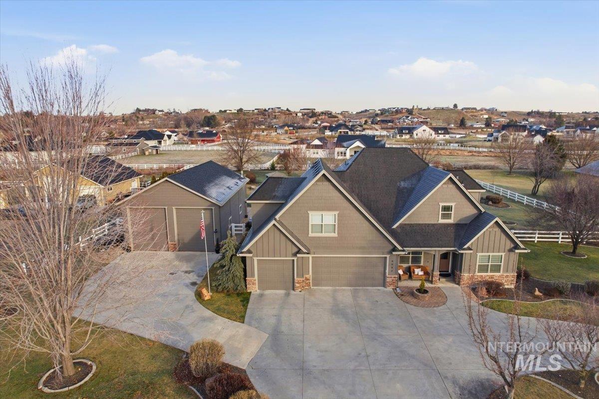 Craftsman inspired home with board and batten siding, stone siding, driveway, a residential view, and a porch